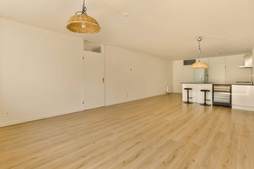 an empty living room with wood flooring and white cupboards on either side of the room, there is a ceiling fan
