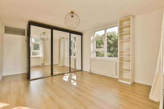 an empty living room with wood flooring and large windows in the room is very clean, but it's all white