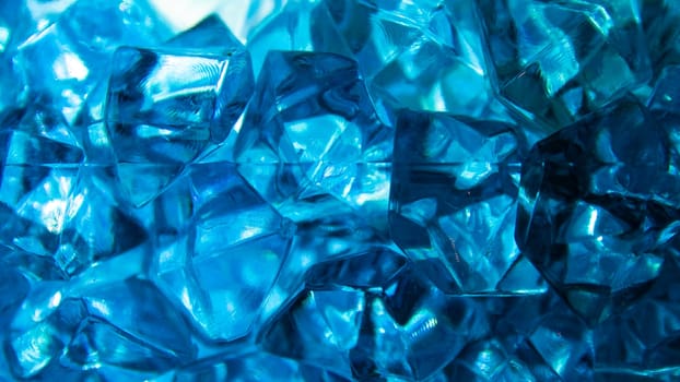 Bright blue crystals made of glass look like gems close-up in the blur. Background from blue stones crystals. Close-up.