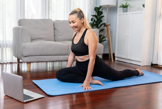 Senior woman in sportswear being doing yoga in meditation posture on exercising mat at home. Healthy senior pensioner lifestyle with peaceful mind and serenity. Clout