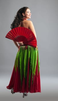Young woman belly dance with fan in oriental arabic costume