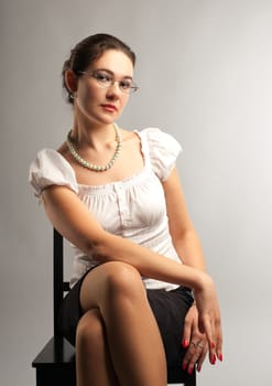 young girl sit in business suit and glasses