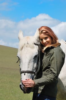 Pretty Girl standing in field with horse