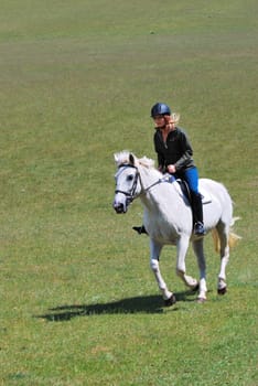 Girl riding horse in field