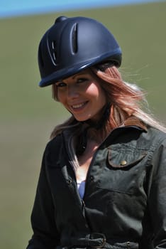Young horseriding girl in safety hat