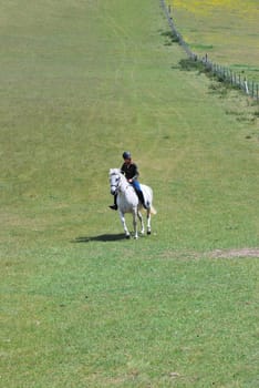Girl riding horse in empty field
