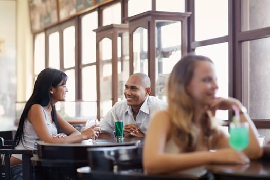 female friends and adult hispanic couple drinking cocktail in pub. Horizontal shape, side view, waist up
