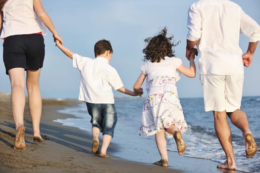 happy young family have fun and live healthy lifestyle on beach