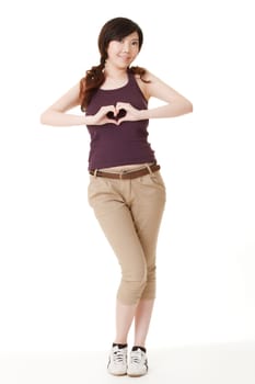 Asian beauty make a heart shape by hand and looking at you, full length portrait in studio white background.