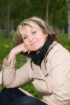 Upper Body Portrait of a Mature Woman Sitting in the Grass