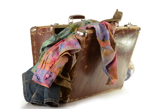 Open old travel suitcese with clothes isolated on white