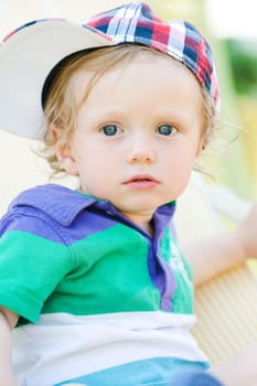 Young child with baseball cap cap and long hair