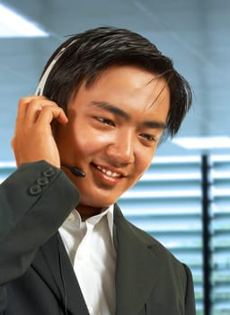 Male Sales Representative In His Office Talking On A Headset To A Customer