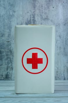 A tall, rectangular white case featuring a red cross icon, typically used for storing first-aid supplies.