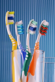 Composition with four toothbrushes on blue background