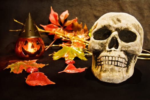 Celebrating Halloween night with scary human skull and pumpkin decoration.