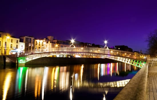 The Ha&#039 penny Bridge over the river Liffey was originally built in 1816 and is now a famous Dublin landmark much loved by tourists and locals alike. Shot was taken on a violet sky evening, long exposure, tripod used.