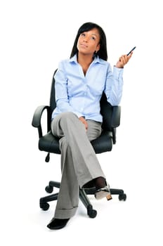Young black businesswoman sitting and thinking in leather office chair