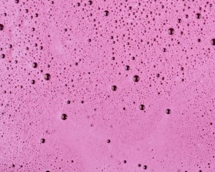 Close-up of blueberry juice bubbles on top of organic blueberry juice.