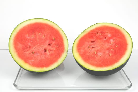 A dark green organic watermelon cut in half.