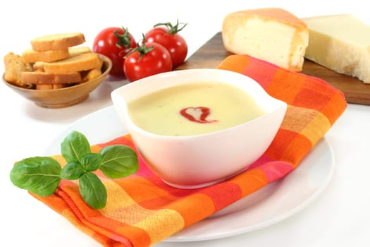 a bowl of cheese cream soup with croutons and basil