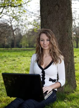 Woman sitting in park with a new laptop