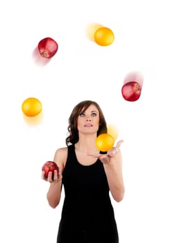 Beautiful woman juggling apples and oranges in motion a white background