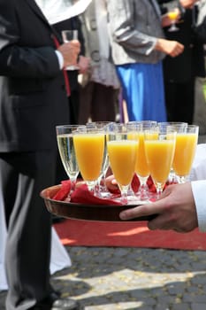 Champagne reception - waiter serves orange juice and sparkling wine