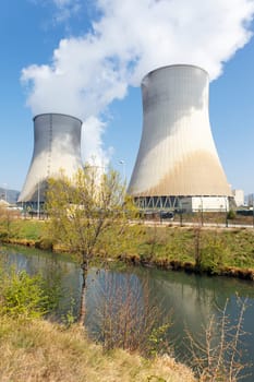 smokestacks of nuclear factory and river in summer