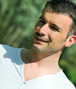 portrait of beautiful man in a natural park