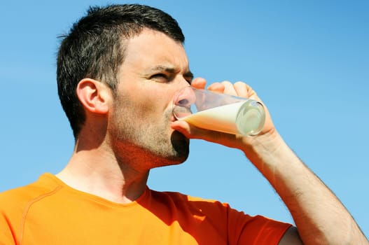 man is drinking fresh glass of milk in the blue skye