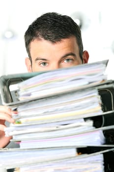 busy man hiding behind a stack of files