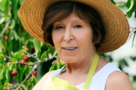 Portrait of a senior woman in a beautiful garden near a cherry tree