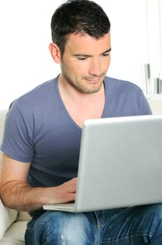 casual attractive man is surfing on web with his computer