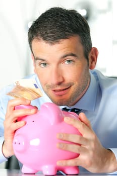 businessman matting a coin in the piggy-shaped pink pig