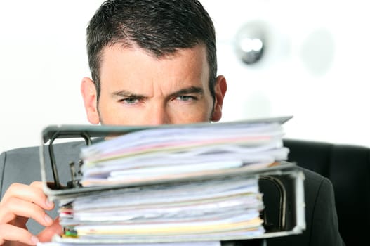 busy man hiding behind a stack of files