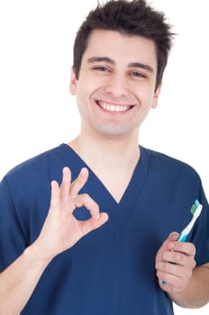 smiling male dentist holding toothbrush and showing ok sign isolated on white background