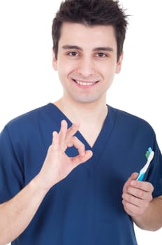 smiling male dentist holding toothbrush and showing ok sign isolated on white background