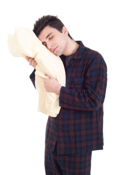happy young man in pajamas holding pillow isolated on white background