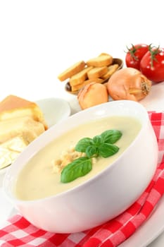 a bowl of cheese cream soup with croutons and basil