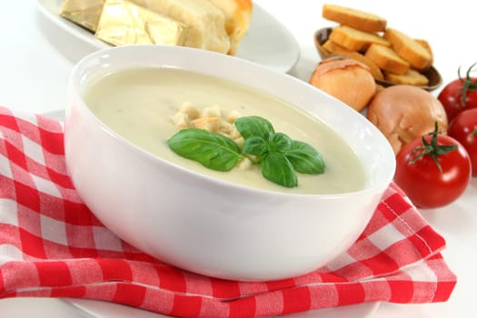 a bowl of cheese cream soup with croutons and basil