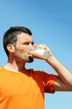 man is drinking fresh glass of milk in the blue skye