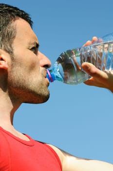 Man is drinking water against blue sky
