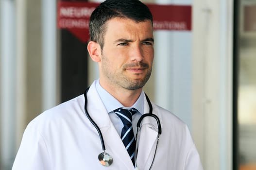 portrait of doctor in front an entrance of the hospital