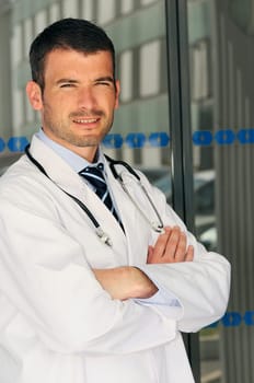 portrait of doctor in front an entrance of the hospital