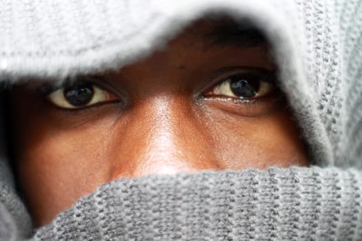 Young young African American - hooded - only the eyes are visible - close-up