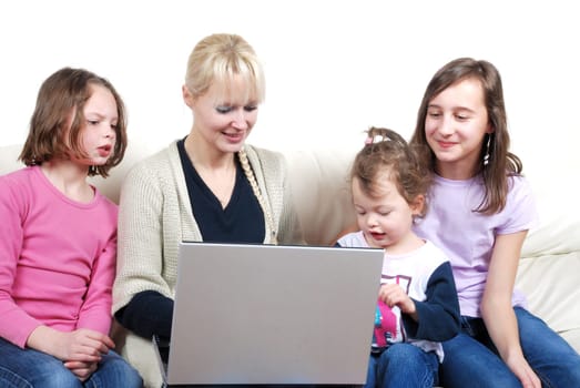 Family sitting on the sofa and using laptop
