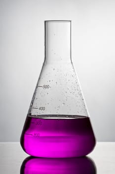 Empty chemistry glass filled with violet liquid