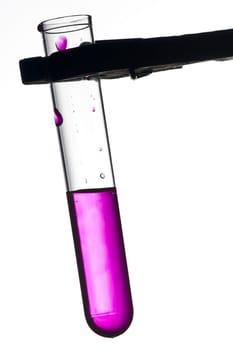 Test tube on clamp with violet liquid