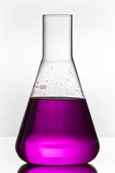 Empty chemistry glass filled with violet liquid